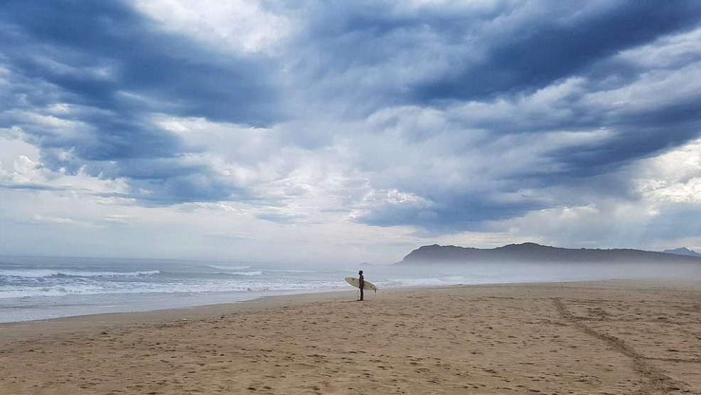Surfer on the beach in Sedgefield, South Africa